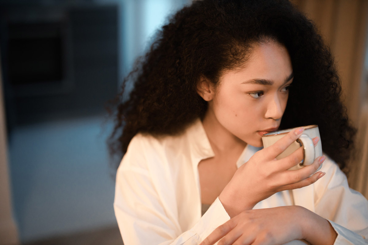 Person sipping beverage from a mug